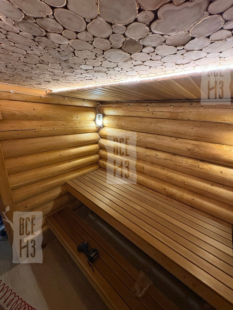 Отделка парной с панно из можжевельника и подсветкой — фото готового интерьера Готовая отделка парной с деревянным панно из можжевельника на потолке и декоративной подсветкой
