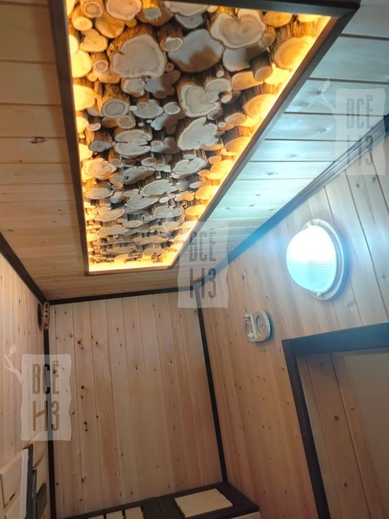 Фото интерьерного 3D панно из можжевельника с натуральной текстурой и подсветкой на потолке парной, создающего уютный и стильный декор в бане.